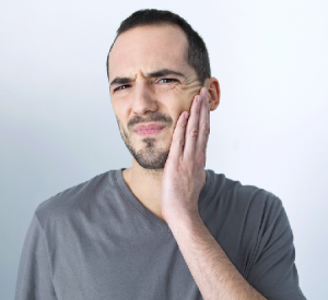 'man holding jaw in pain'